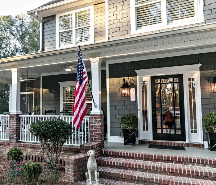 New entry door with a grey home with front porch 